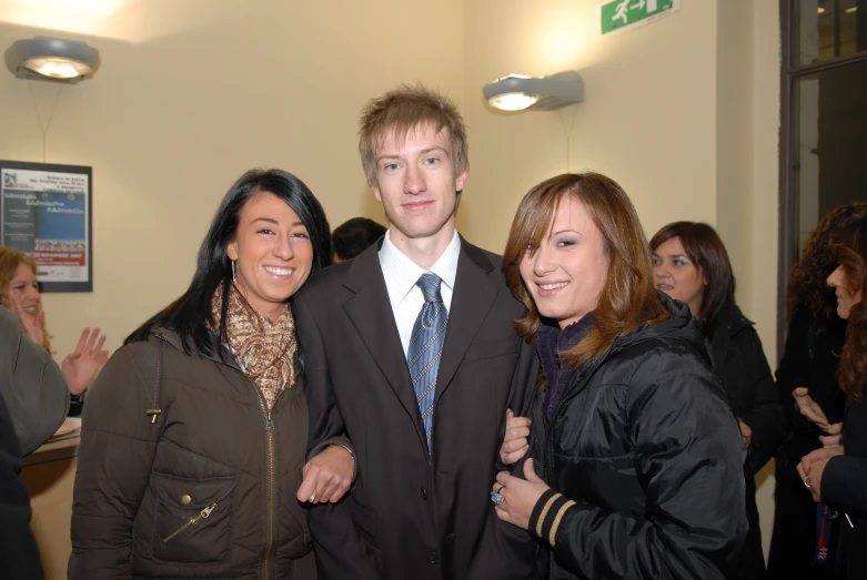 four people smiling in a crowded office building