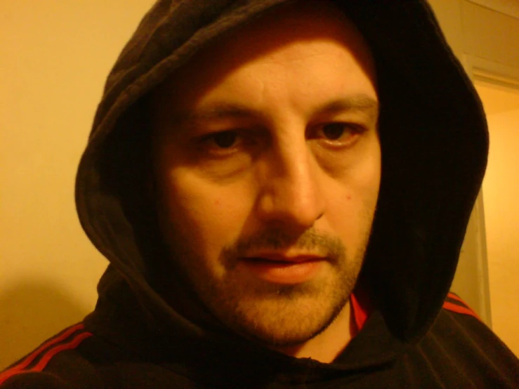 a man wearing a hoodie in front of a mirror