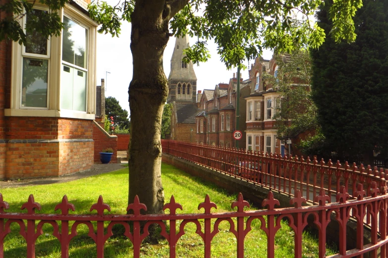 a brick house sits near a tree on a sunny day