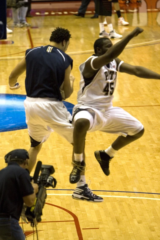 some players are playing basketball on a court