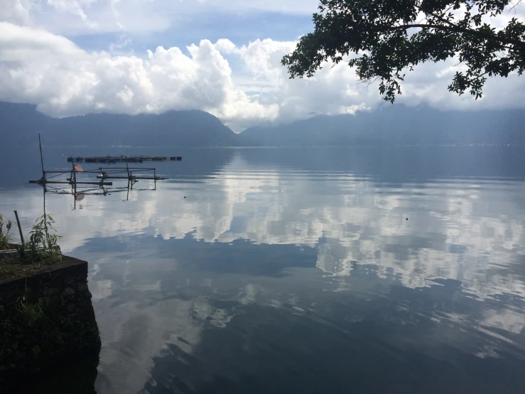 the clouds are reflected in the water, at the lakeside