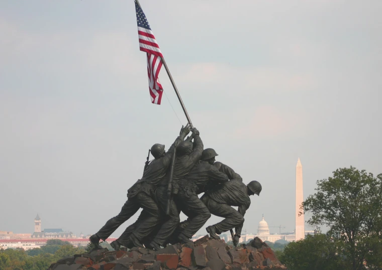 a group of army statues holding the american flag