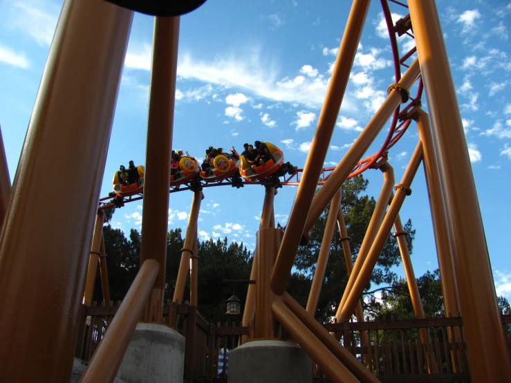 roller coaster rides in an amut park against a bright blue sky