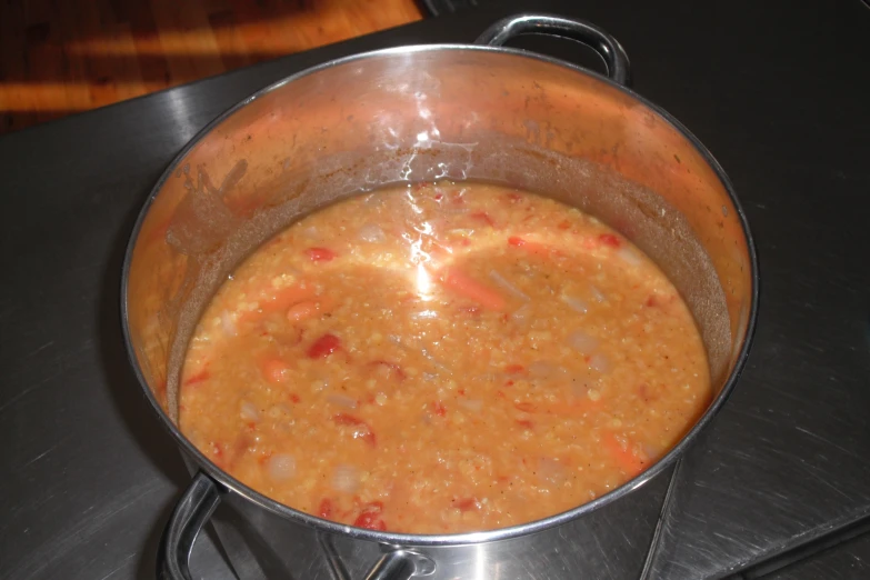 a stainless steel pot with soup inside