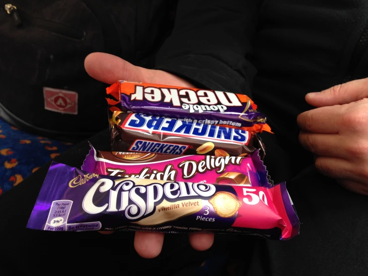 a man holding three types of candies in his hand