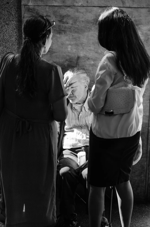 a little boy and woman watch a baby sit in a walker