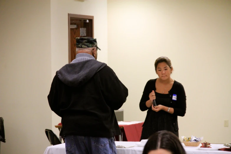 a person standing in front of a man who is giving a presentation