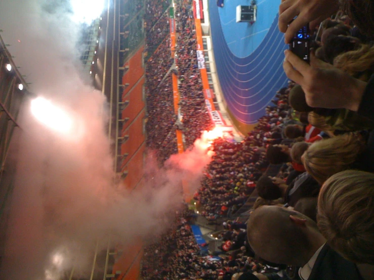 the crowd looks on as a fireball shoots out of its hole