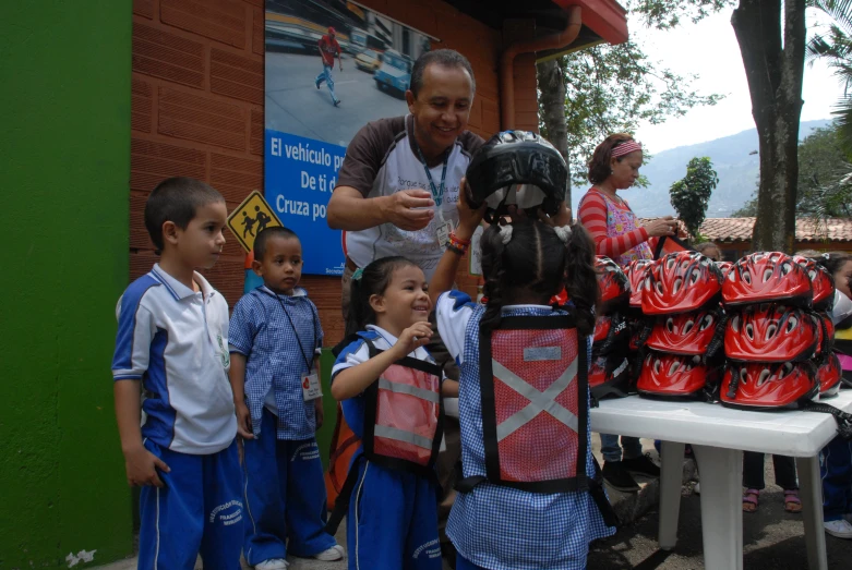 a man putting a helmet on a child's back