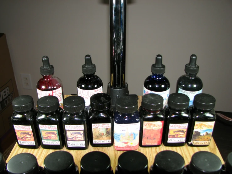 various jars with black lids lined up on a table