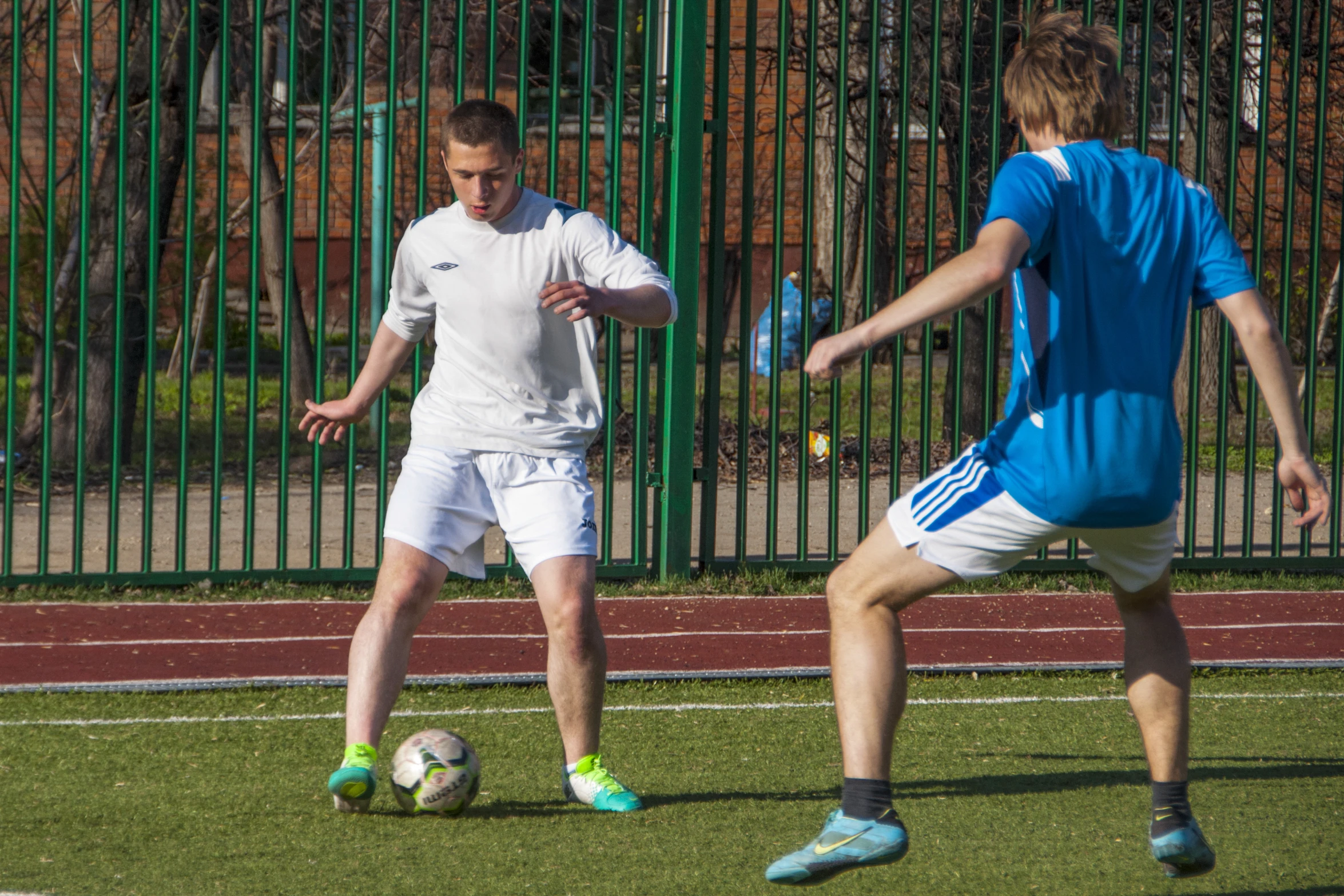 two people in uniforms playing soccer on the field