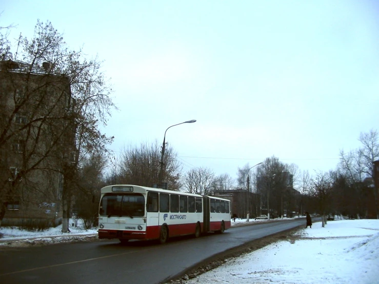 a bus driving down the road next to a building