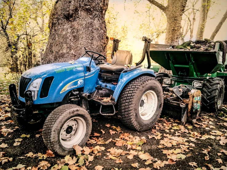 the tractor is parked under a large tree