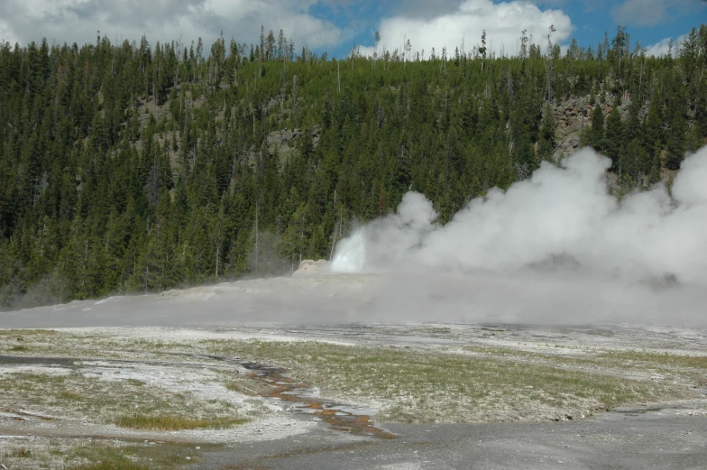 a few jets of water emitting steam from a lake