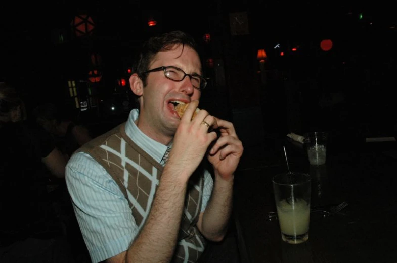 a man is eating in a bar at night