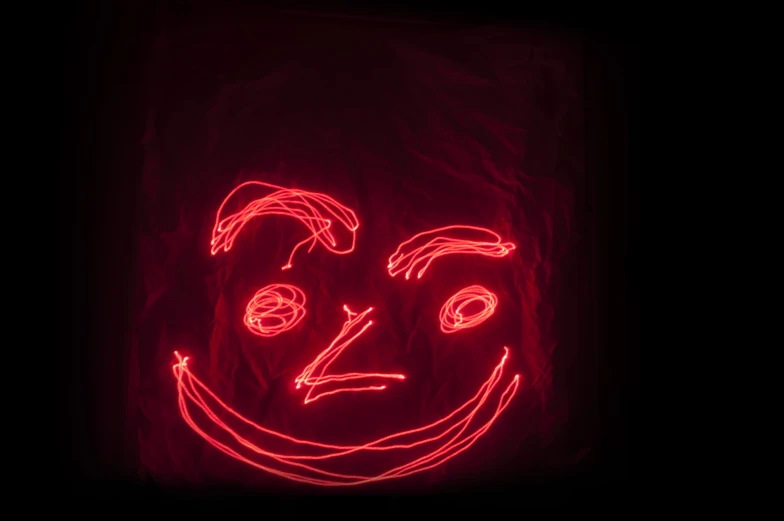 a neon drawing in the shape of a scary face