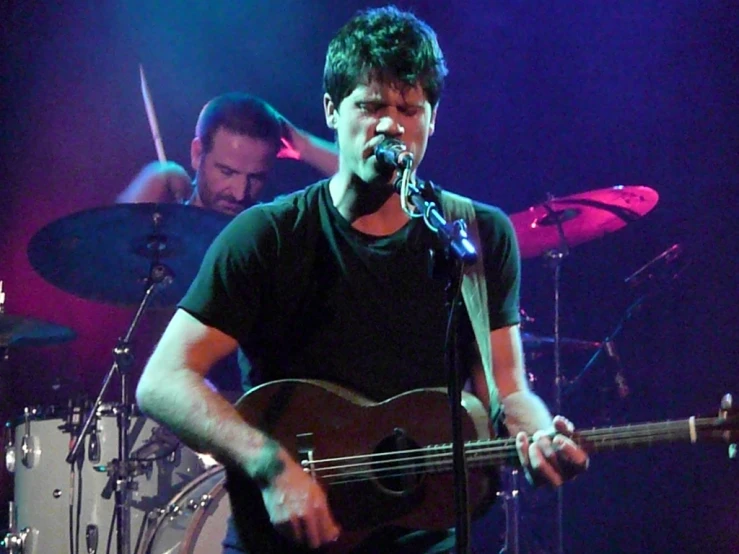 a man standing next to a keyboard and singing