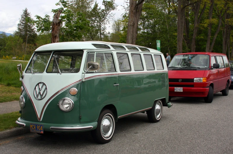 a green vw bus stopped at a red car