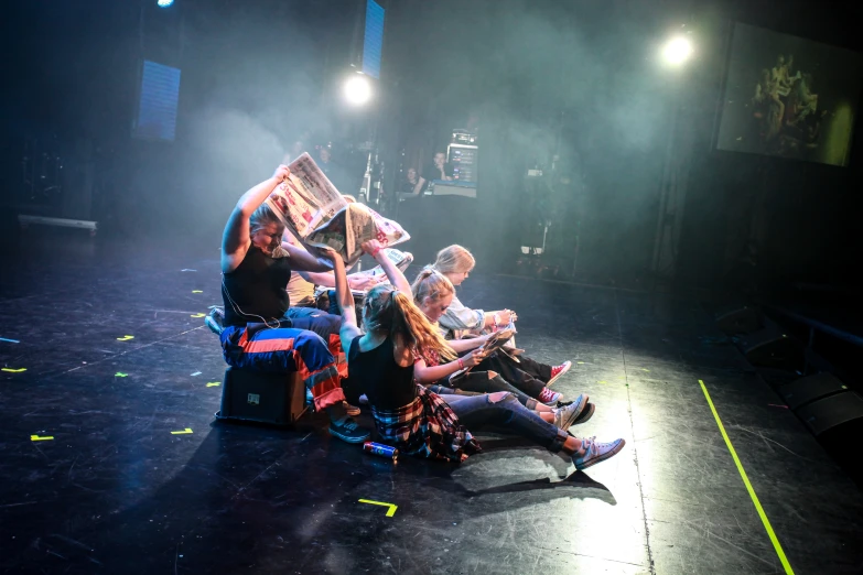 a group of people sit on the stage while they watch the show