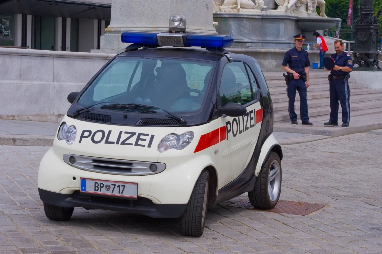 a police car parked in front of a fountain