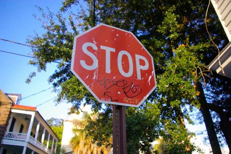 stop sign with graffiti on the bottom and below