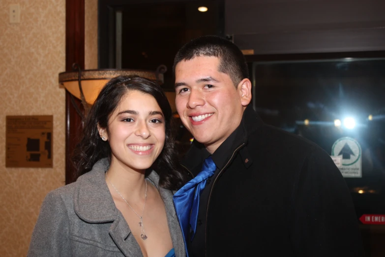 a woman standing next to a man in suit and tie