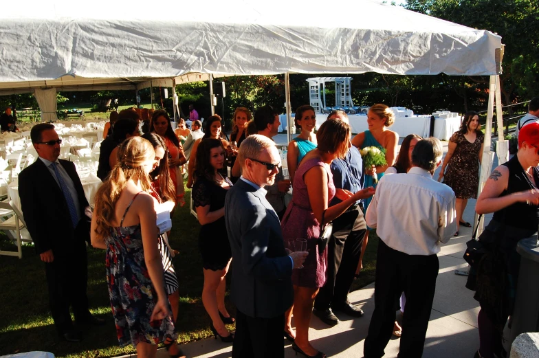 a group of people are standing under a tent