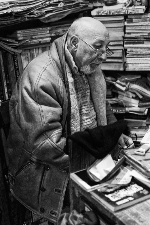 a man is sitting at a desk with many books