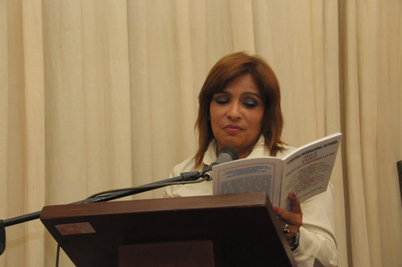 a woman in a white shirt is reading a book