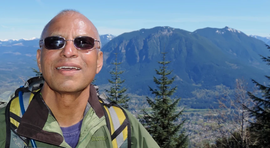 balding man with sunglasses overlooking the mountains