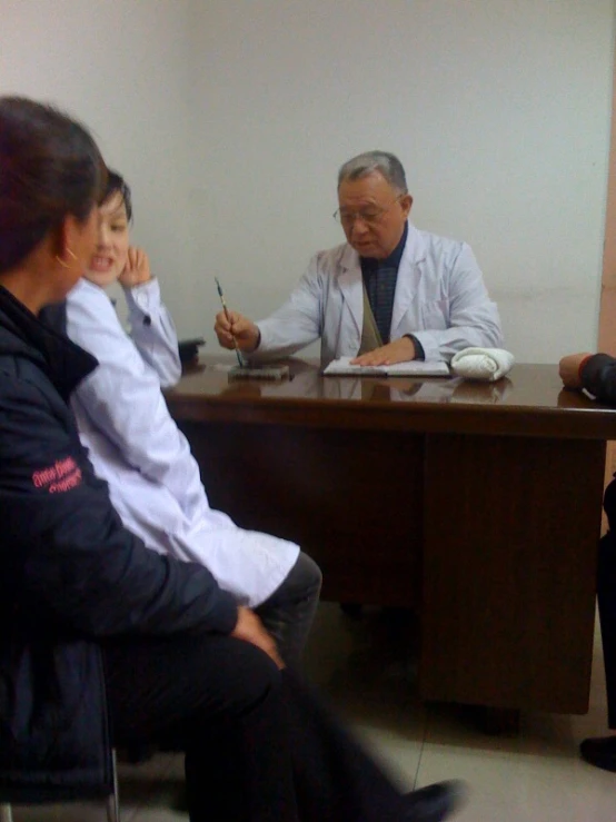 a woman in a blue shirt sitting in a chair while talking on the phone