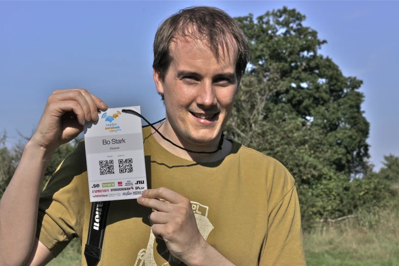 a young man holds a pack of paper and sticks it with his tongue