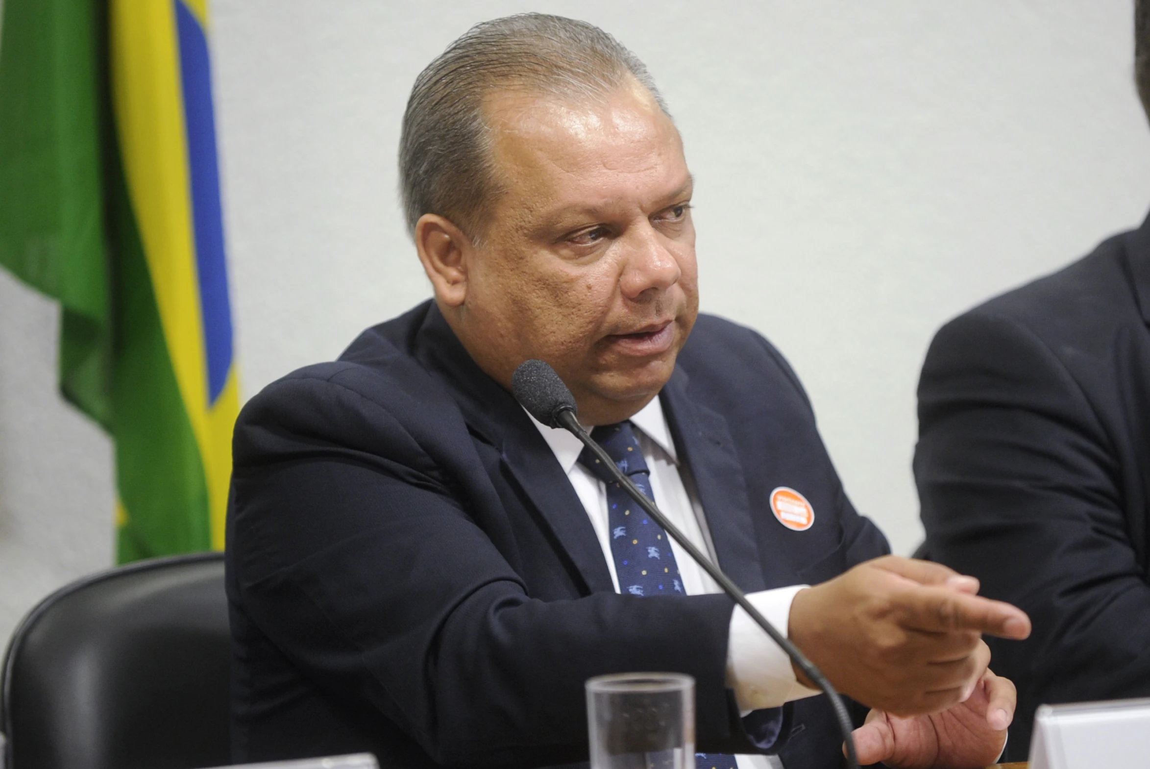 a man in suit and tie sitting at table talking