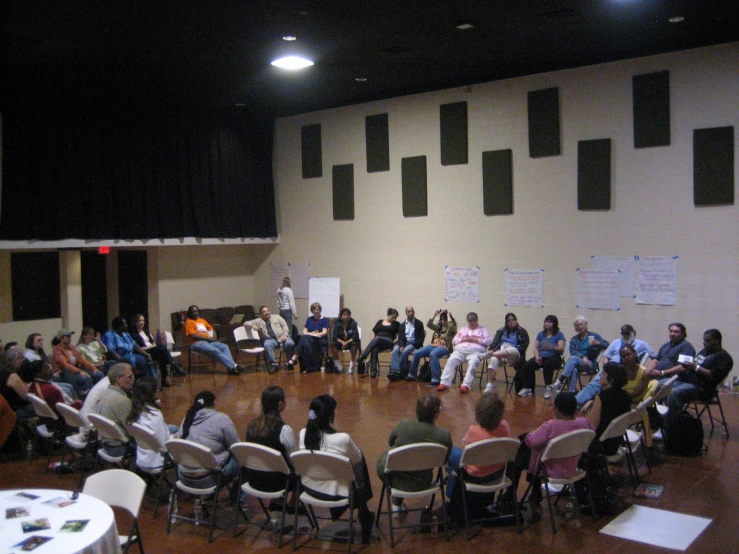 group of people in chairs at the back of a large round room