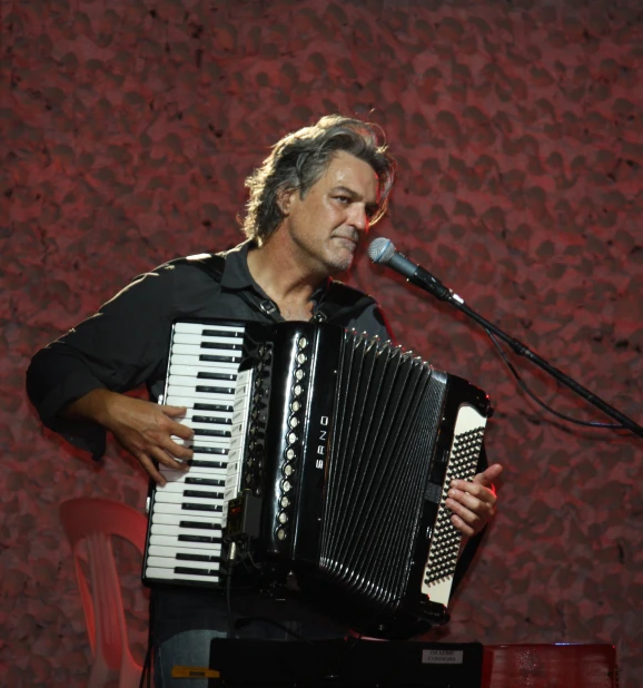 a man holding a accordion playing a music instrument