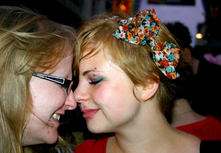 two girls are sharing an awkward moment as one girl puts her eyeliners on another