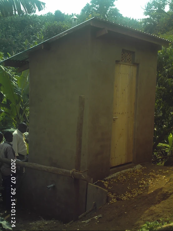 a small shed with a door next to a garden