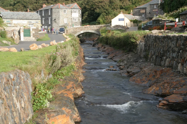 a small river passing by houses next to a bridge