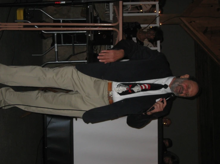 man in jacket and tie standing in front of crowd