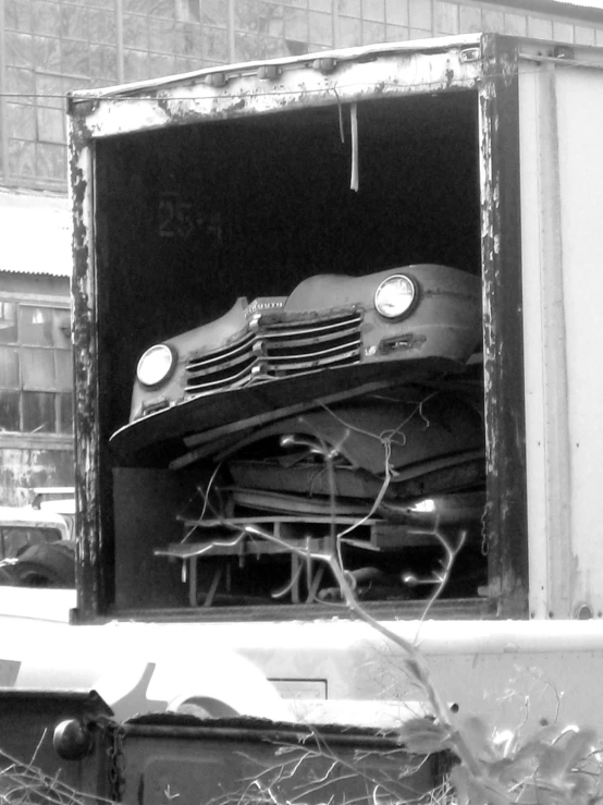 the old pickup truck is in the storage area of the building