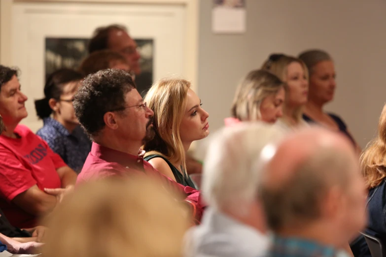 several people sitting side by side in a room