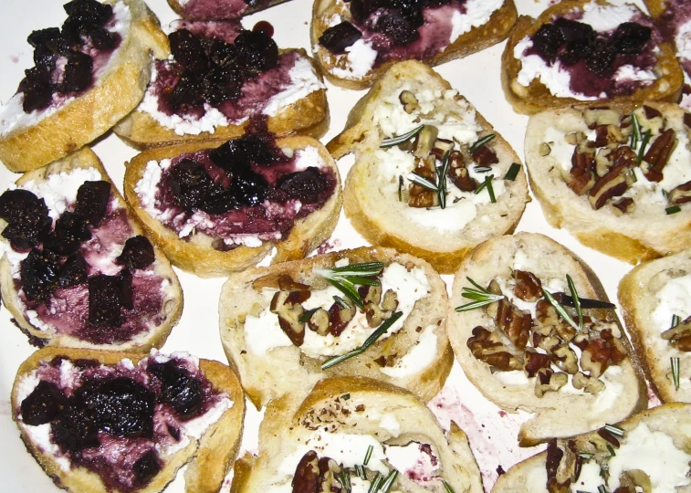 an assortment of mini bread with toppings is displayed