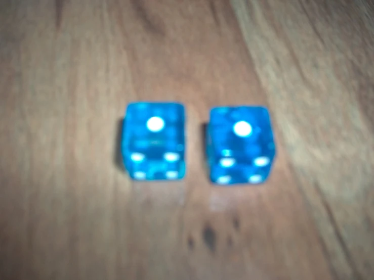 two pieces of dice on a wood surface