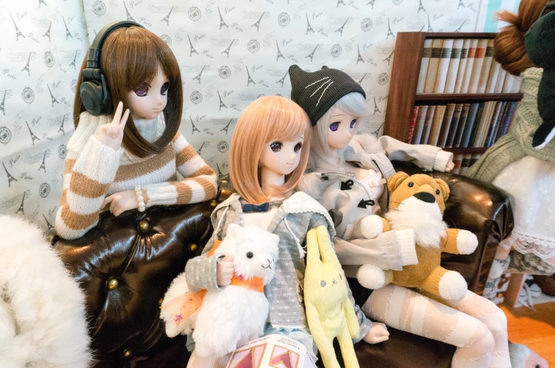 several stuffed animals posed on the sofa while wearing headphones
