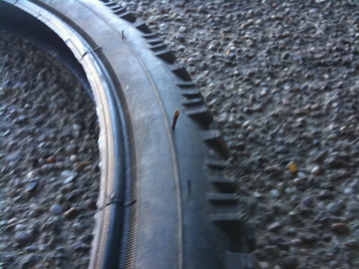 an old bicycle tire laying on some gravel