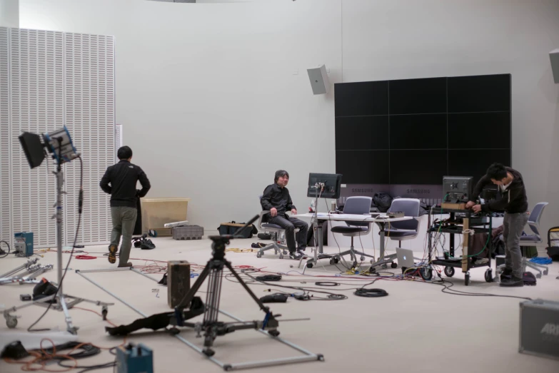 three men with camera equipment in an office