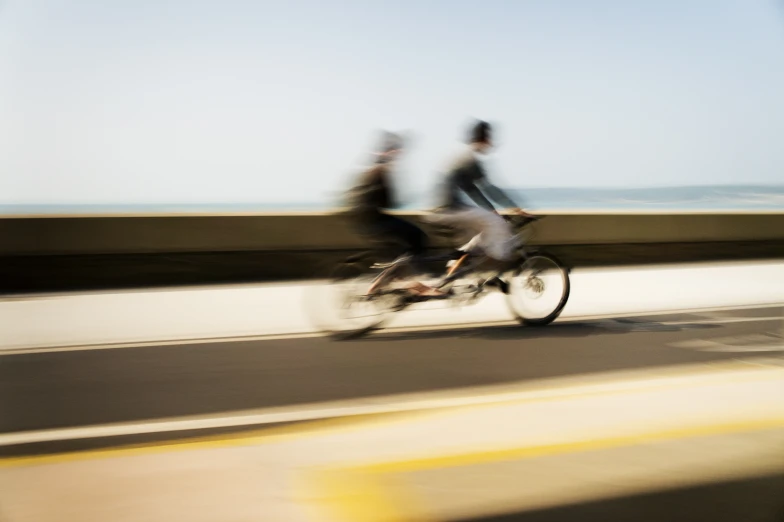 people riding on a bike along a road