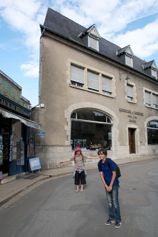 a boy is standing in front of an old building