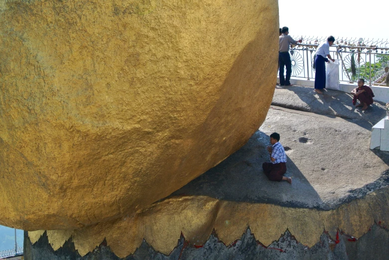 three people are sitting on the cement outside