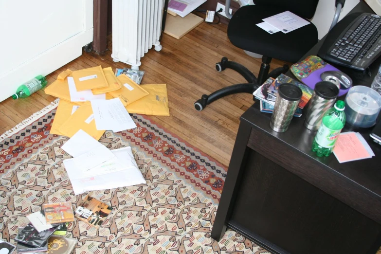 the carpet is covered with papers, plastic bottles and a laptop